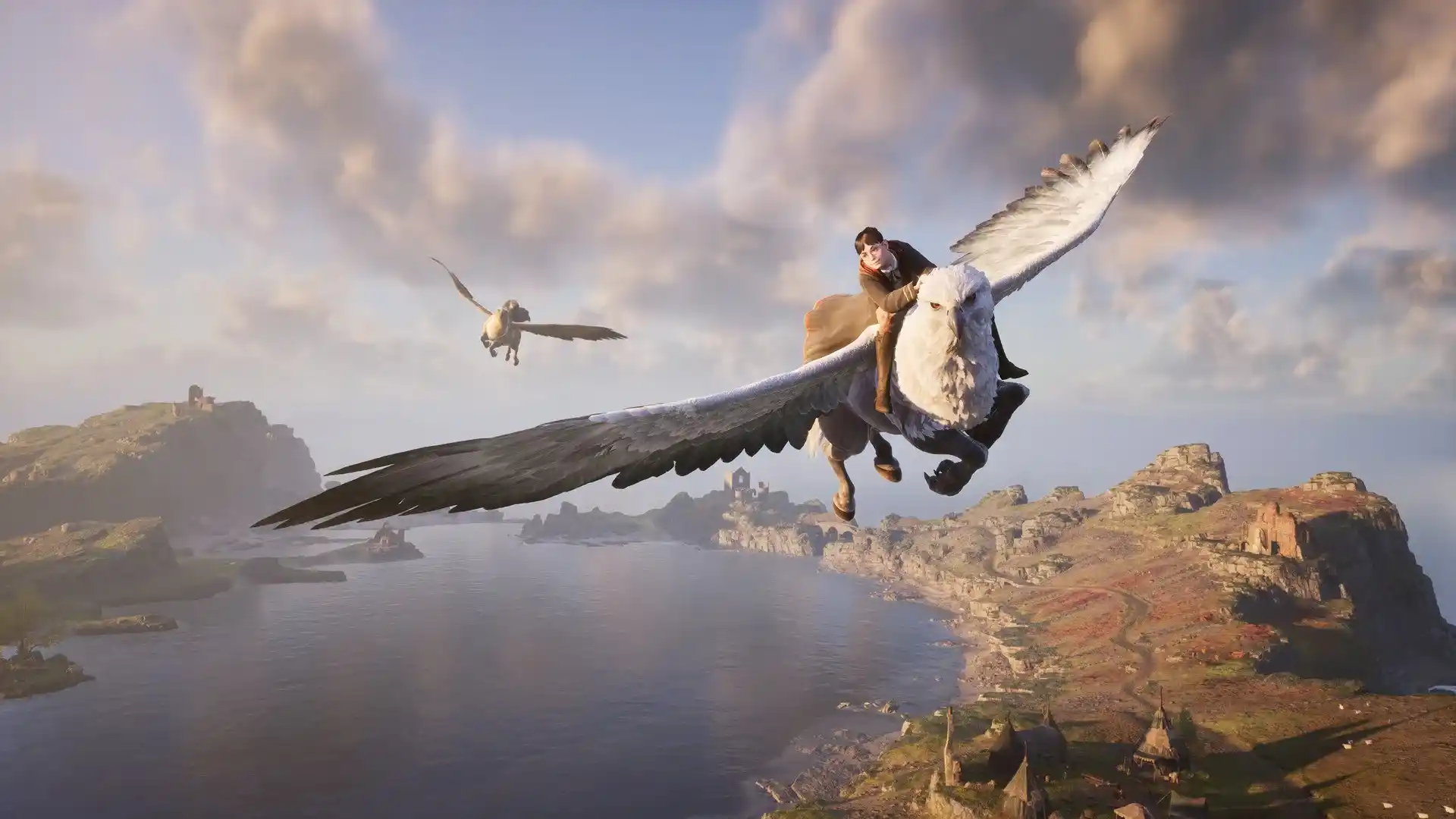 Un estudiante de Hogwarts Legacy vuela en hipogrifo sobre el lago y las tierras altas del mundo abierto del juego