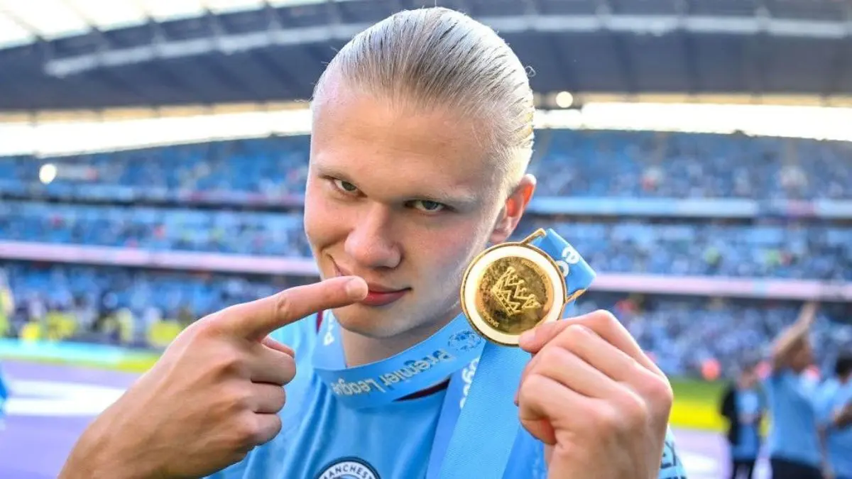 Erling Haaland señala la medalla que ganó con el Manchester City en la Premier League