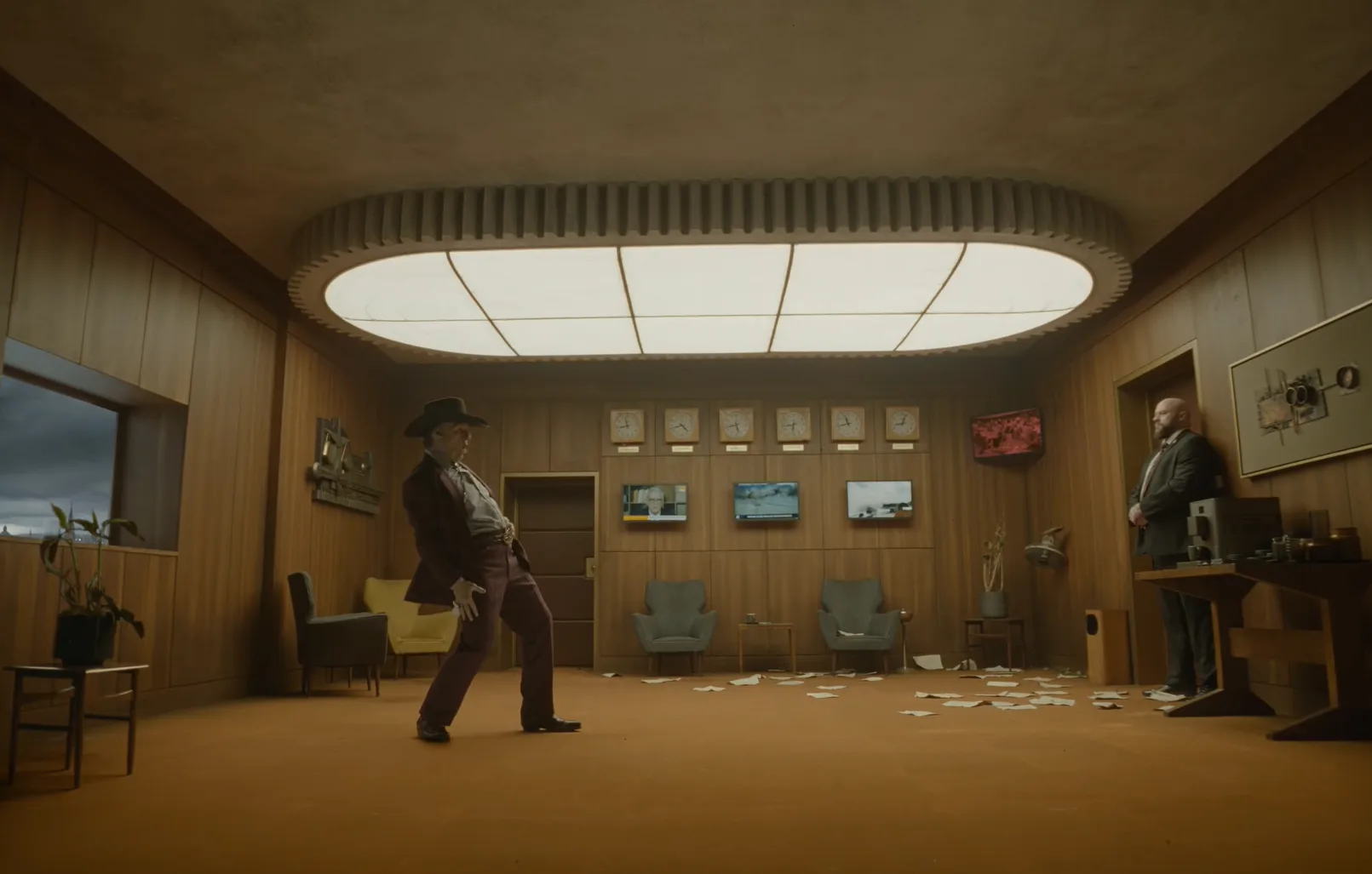 Tom Cruise, de sombrero, camina por una oficina cubierta de papeles en una escena de Digger