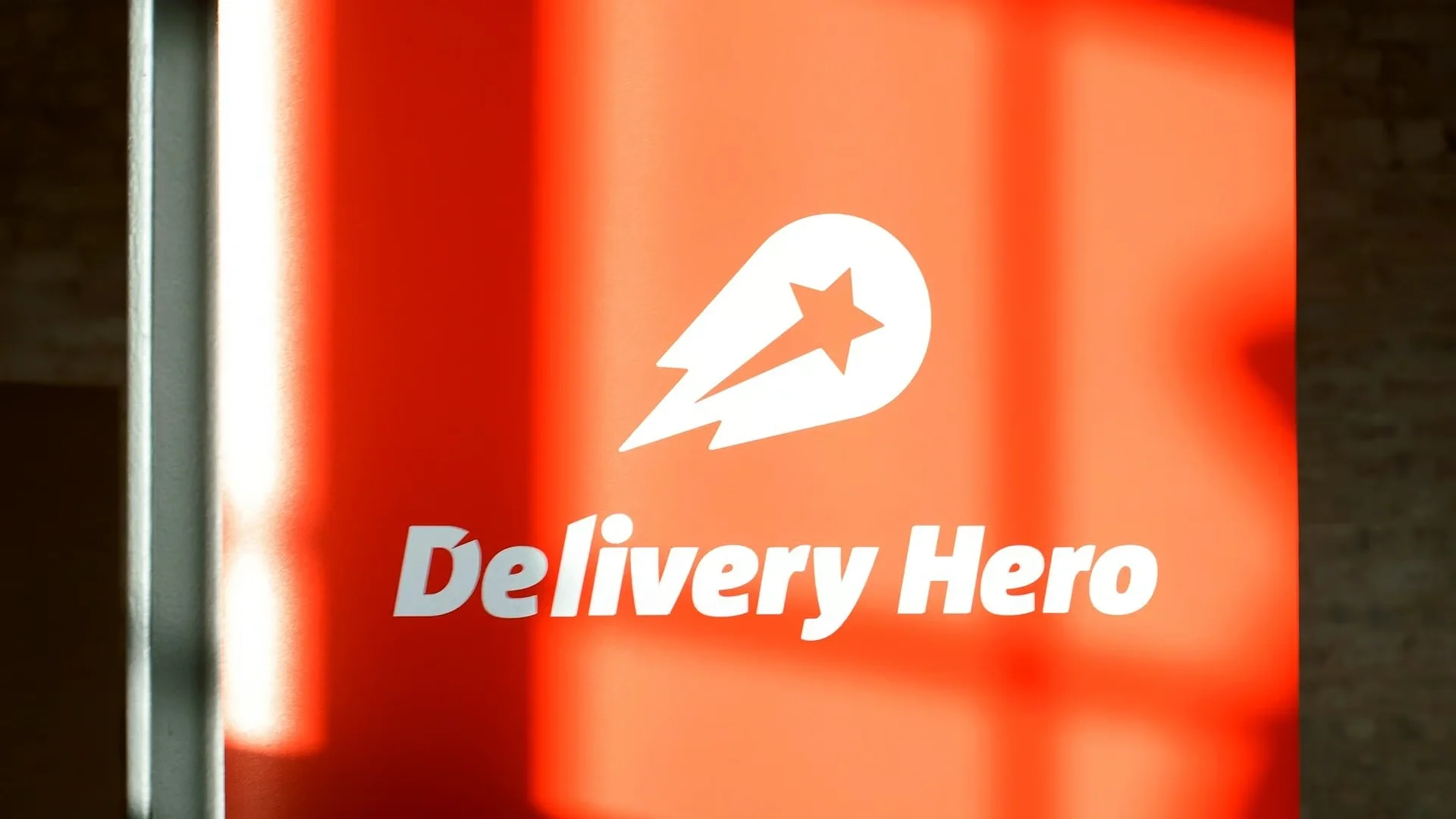 Cartel con el logo de Delivery Hero iluminado en sus oficinas