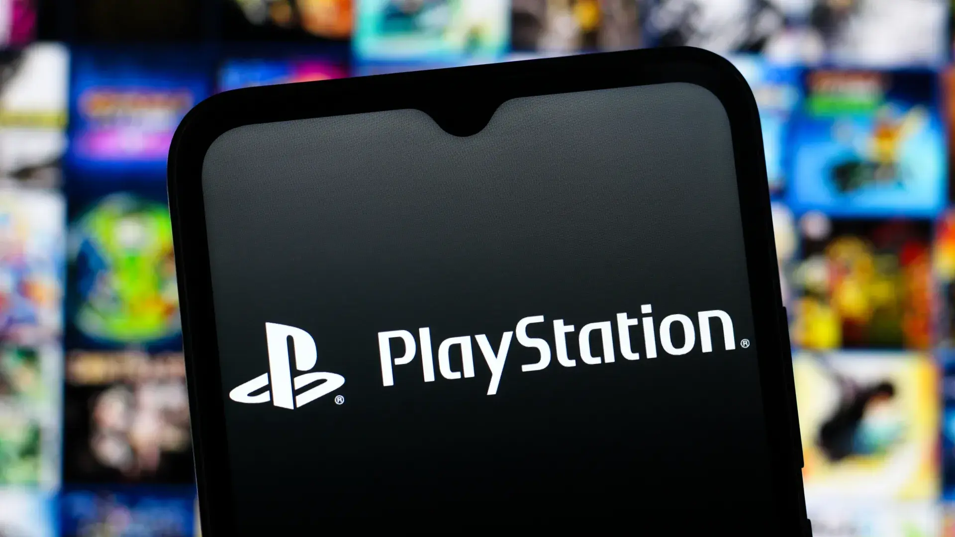 Logo de PlayStation en la pantalla de un celular, con juegos de fondo, tras la caída de PlayStation Network