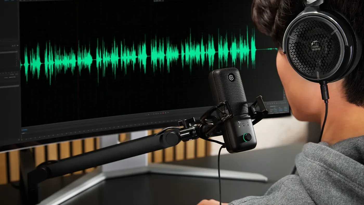 Primer plano del micrófono Elgato Wave:3 MK.2 con anillo LED y dial multifunción, usado con auriculares