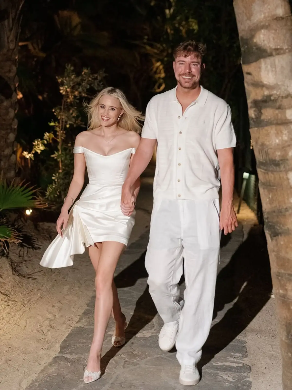 Thea Booysen con un vestido blanco corto junto a MrBeast durante la fiesta nocturna del casamiento