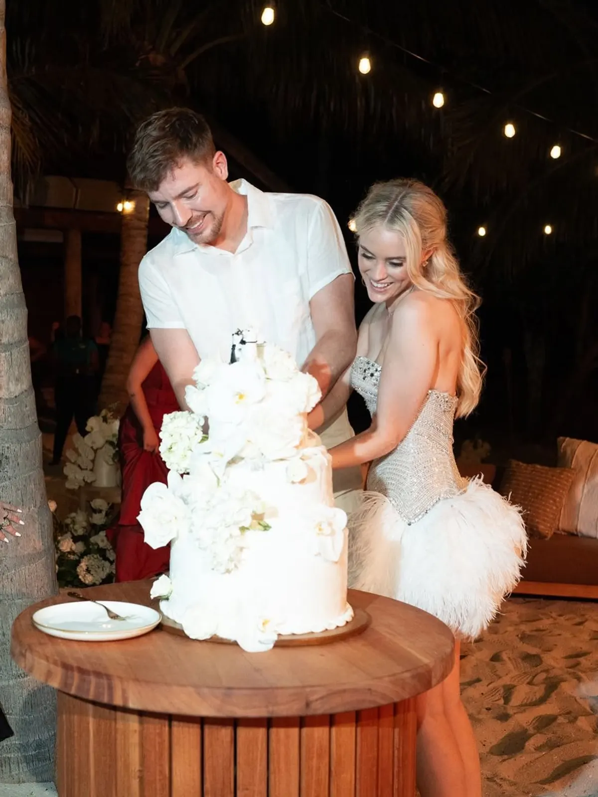 MrBeast y Thea Booysen cortan la torta de casamiento durante la fiesta al aire libre