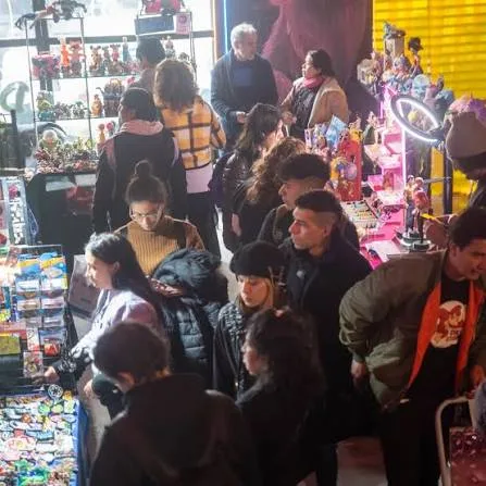 Visitantes recorriendo un stand de merchandising de cultura pop en la feria Nerdo