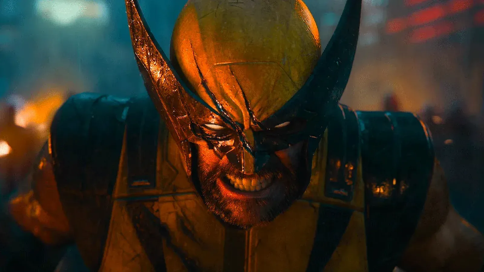 Wolverine con la máscara amarilla rasgada, sonriendo de forma desafiante en primer plano