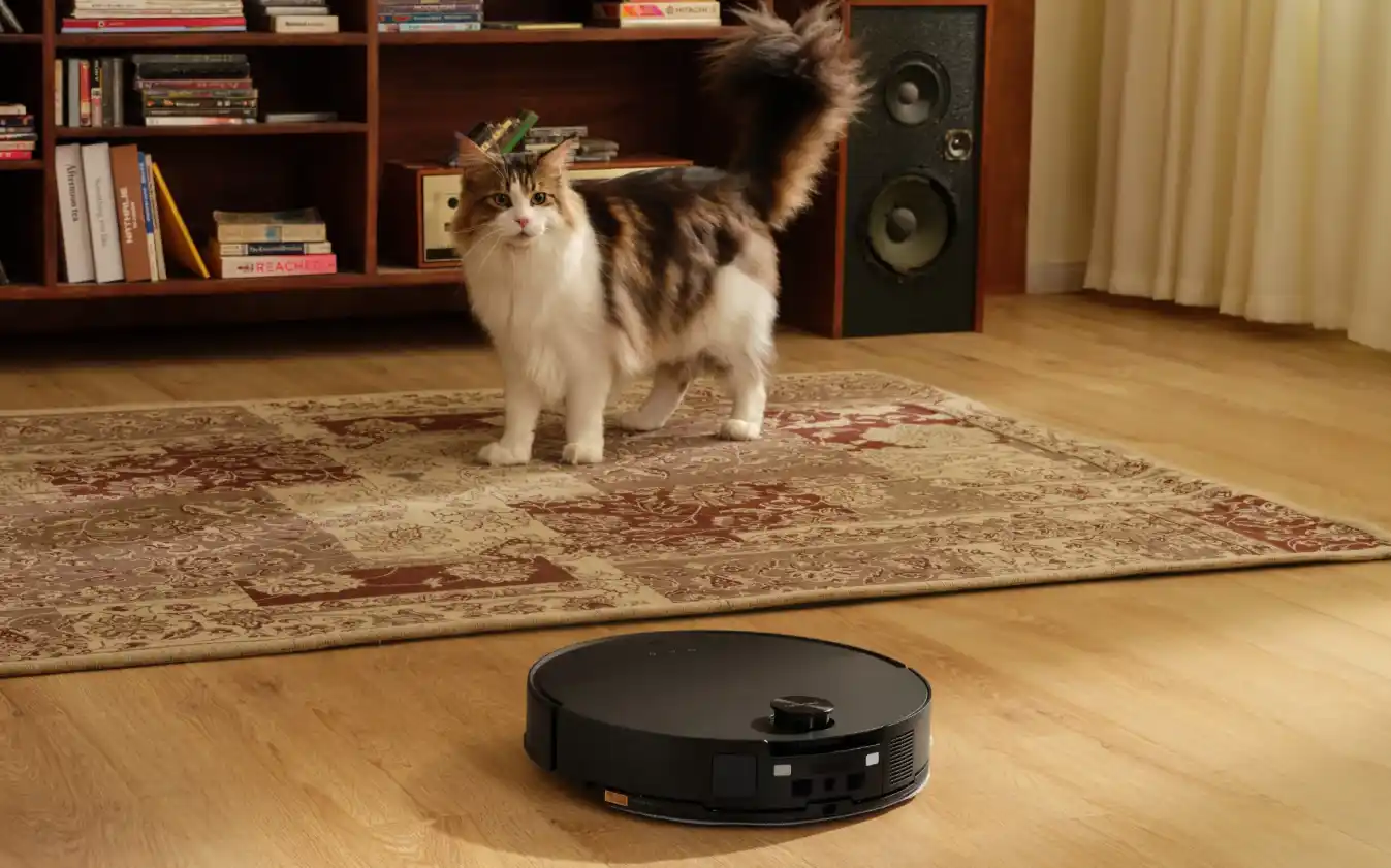 Aspiradora robot Roborock limpiando el piso de un living junto a un gato