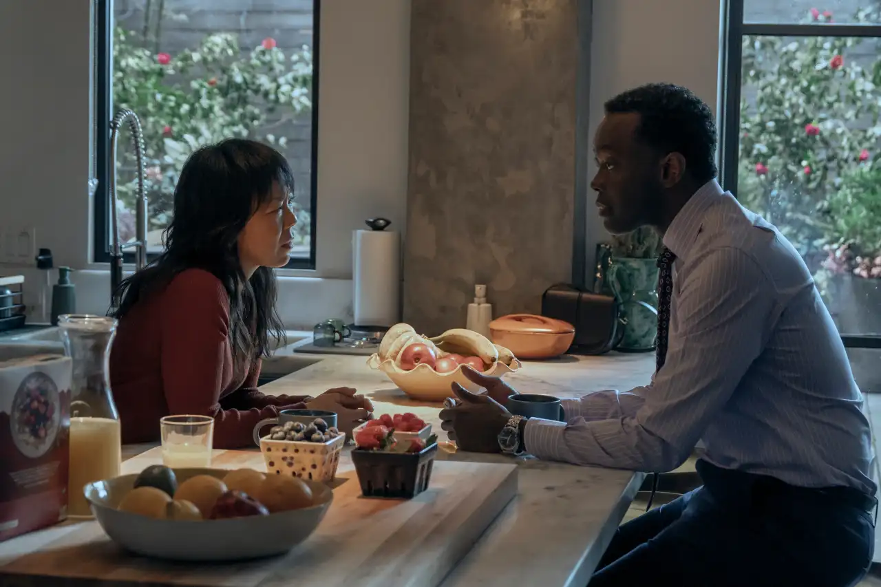 Ali Ahn y Ato Essandoh como Eidra Park y Stuart Hayford en una cocina en The Diplomat temporada 4
