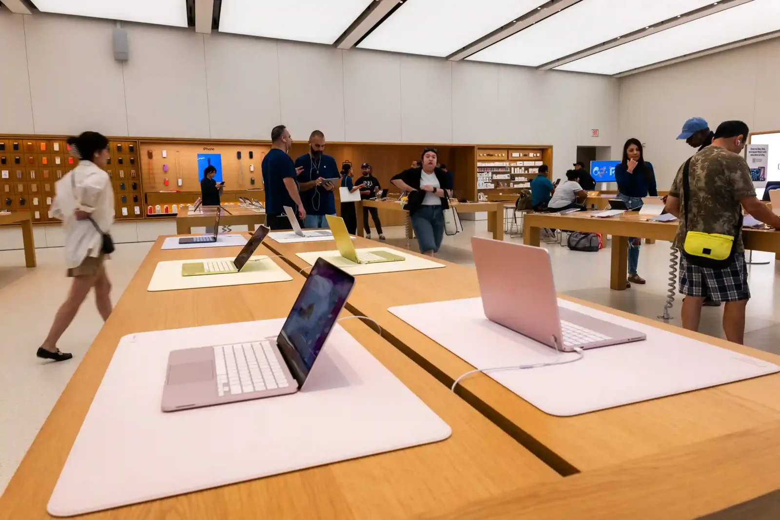 MacBook en exhibición sobre las mesas de madera de una Apple Store