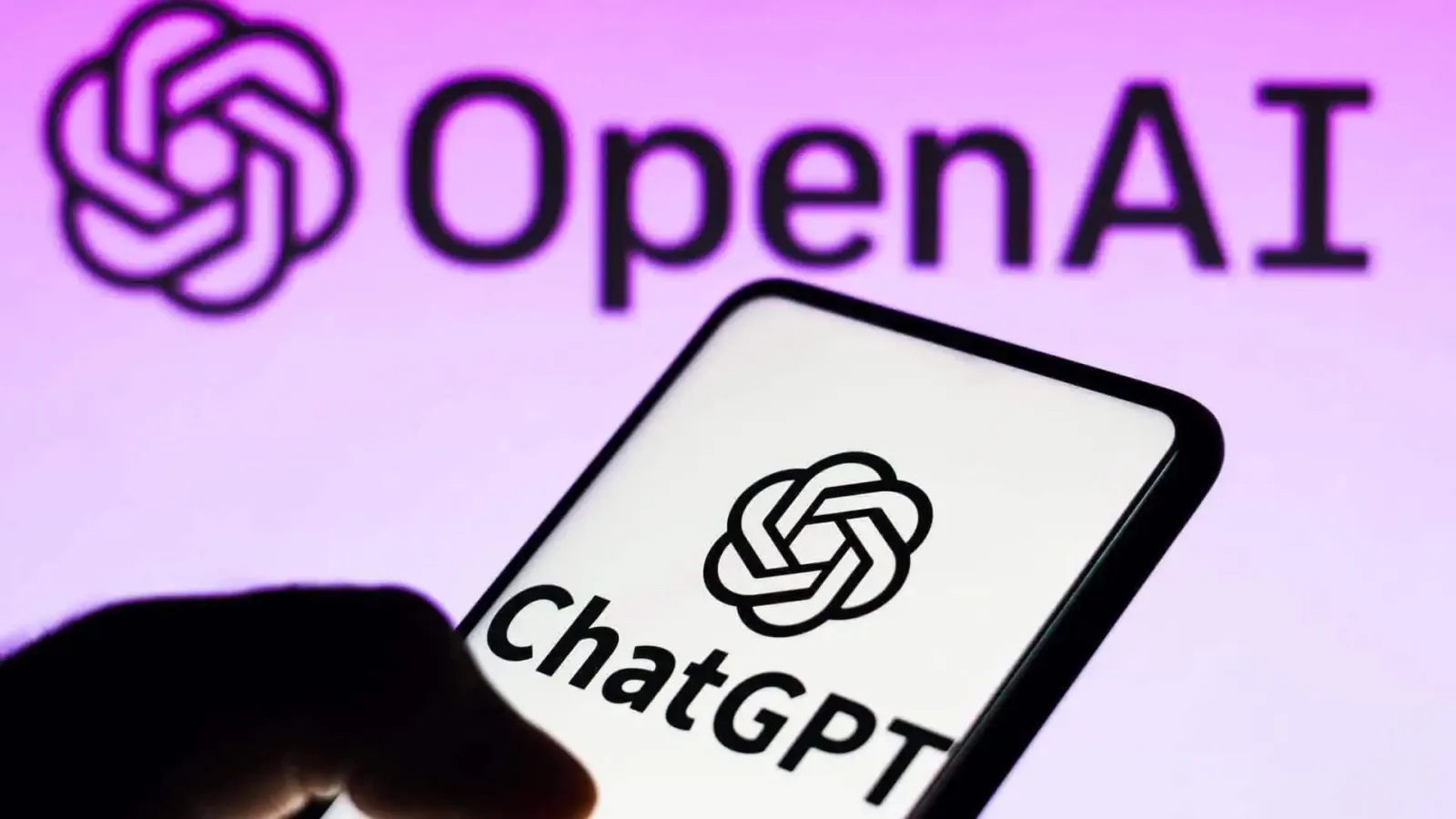 Logo de OpenAI detrás de un celular con el logo de ChatGPT en pantalla, la empresa detrás de ChatGPT para adolescentes