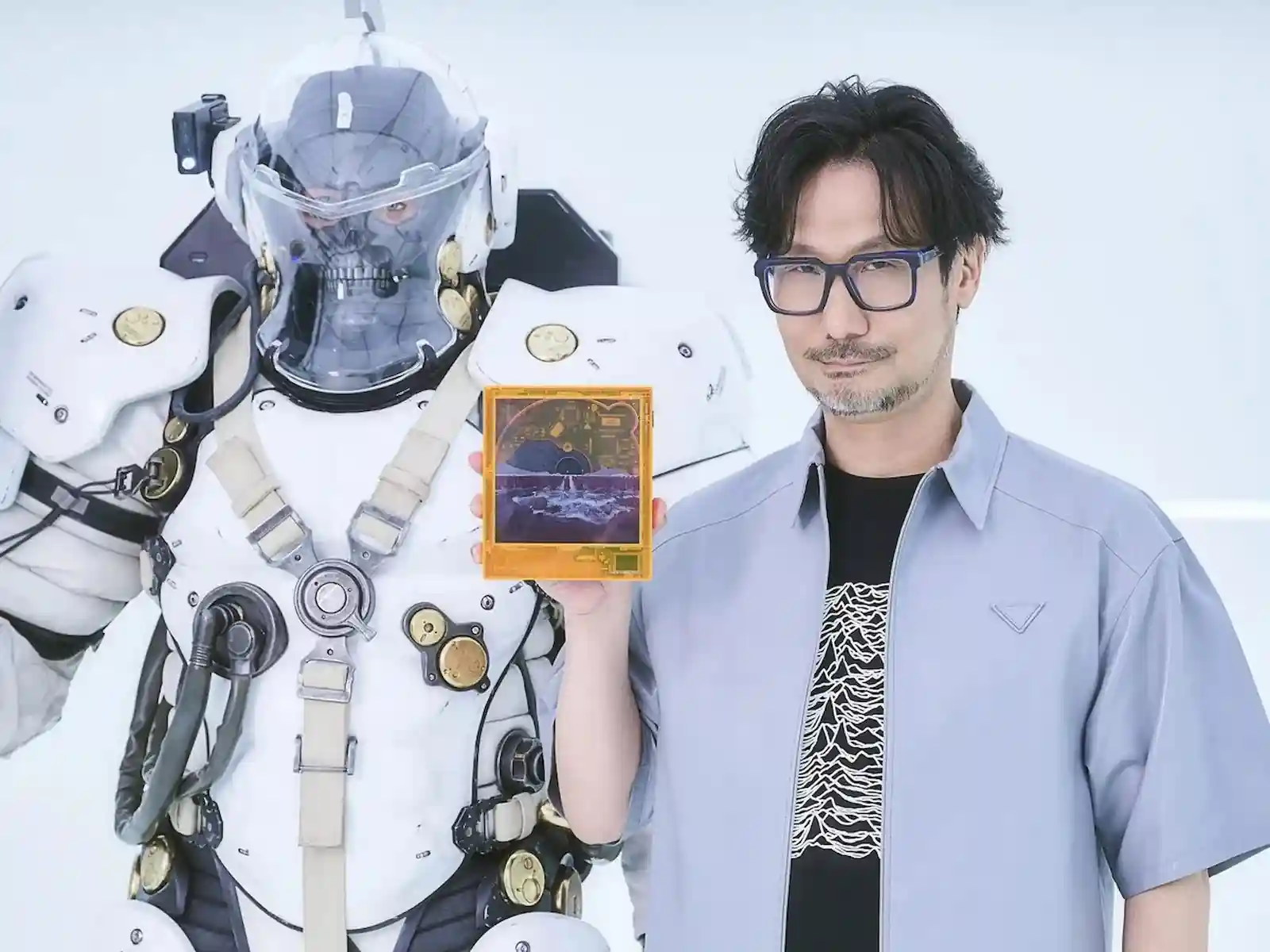 Hideo Kojima sostiene el Discman de Death Stranding 2 junto a una figura de BB