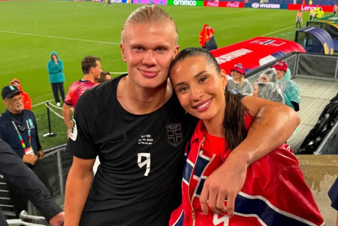 Erling Haaland con la camiseta de Noruega abrazado a Isabel Haugseng Johansen, envuelta en la bandera noruega