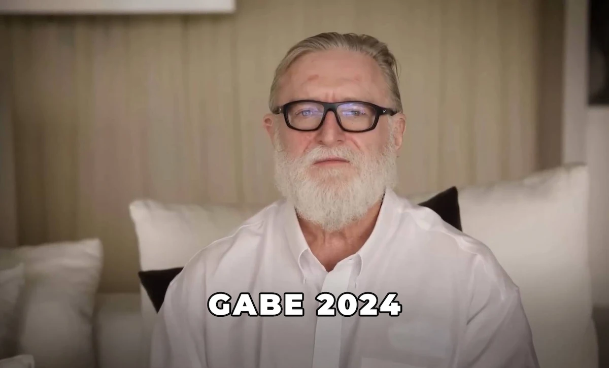 Gabe Newell en 2024, con camisa blanca y la barba todavía tupida, en un living