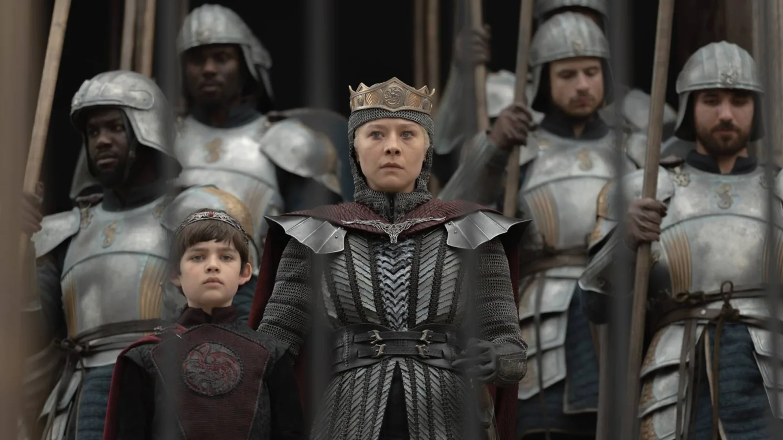Rhaenyra Targaryen con corona y armadura, rodeada de guardias, en el final de la temporada 3 de House of the Dragon