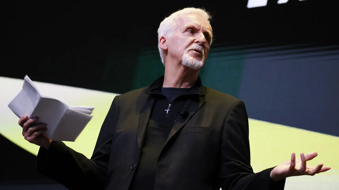 James Cameron hablando en un escenario, con unas hojas en la mano