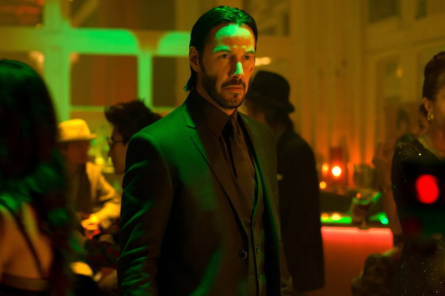 Keanu Reeves como John Wick en la discoteca del Red Circle, con luces verdes y rojas