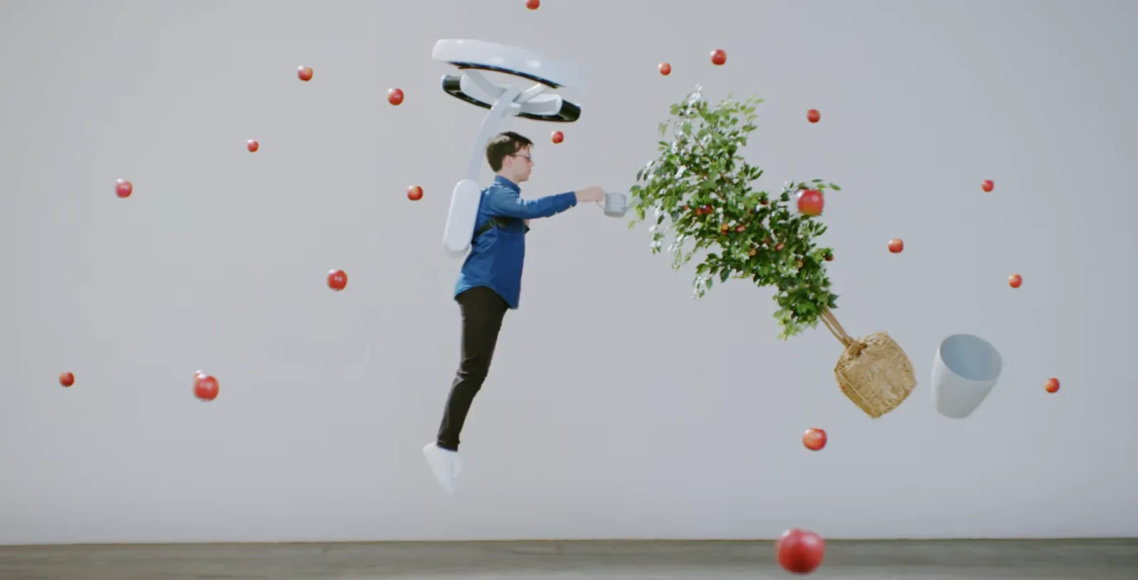 Una persona flota con la mochila de rotores Lunavity entre manzanas y un árbol suspendidos en el aire