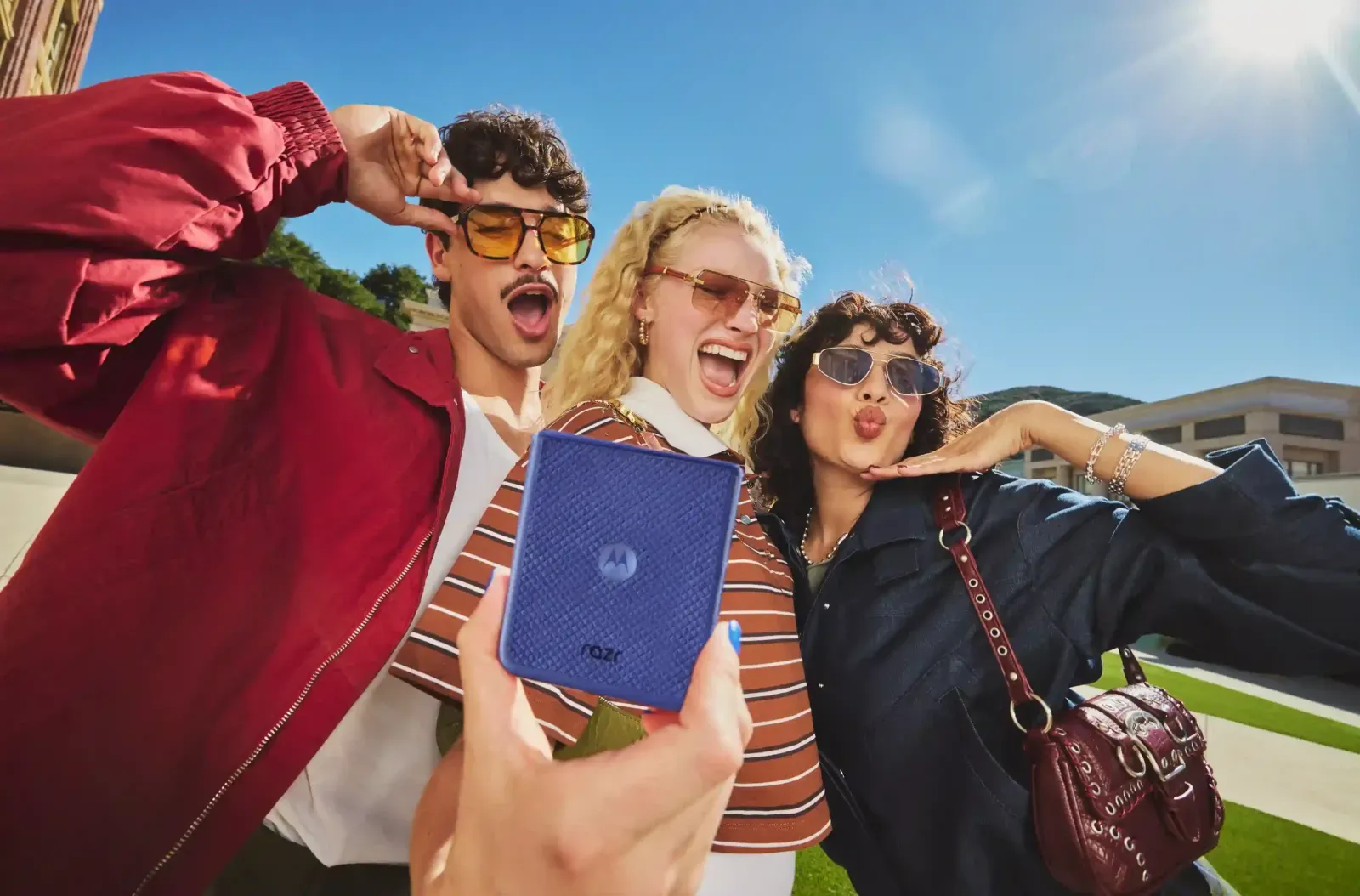 Tres jóvenes posan para una selfie con un motorola razr plegable azul, uno de los equipos en promoción de Motorola por el Día del Niño