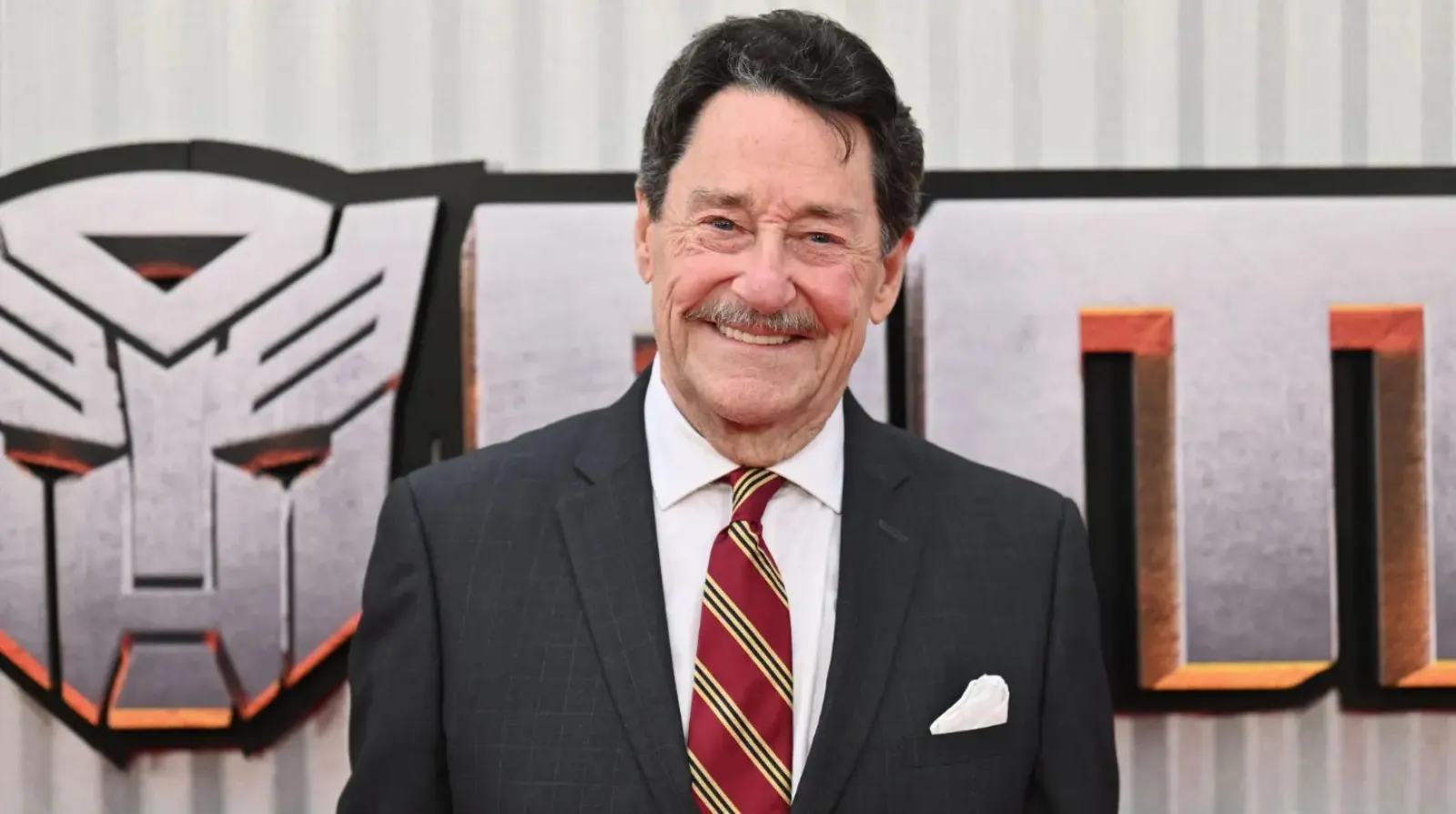 Murió Peter Cullen, el actor de voz de Optimus Prime, retratado delante del logo de los Autobots