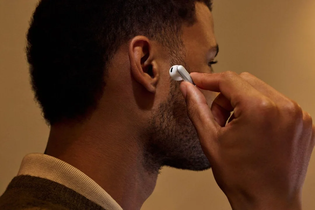 Un hombre se coloca uno de los auriculares Plaud One en la oreja
