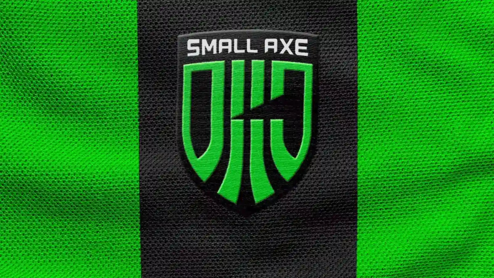 Escudo de Small Axe Studios bordado en verde sobre una camiseta deportiva