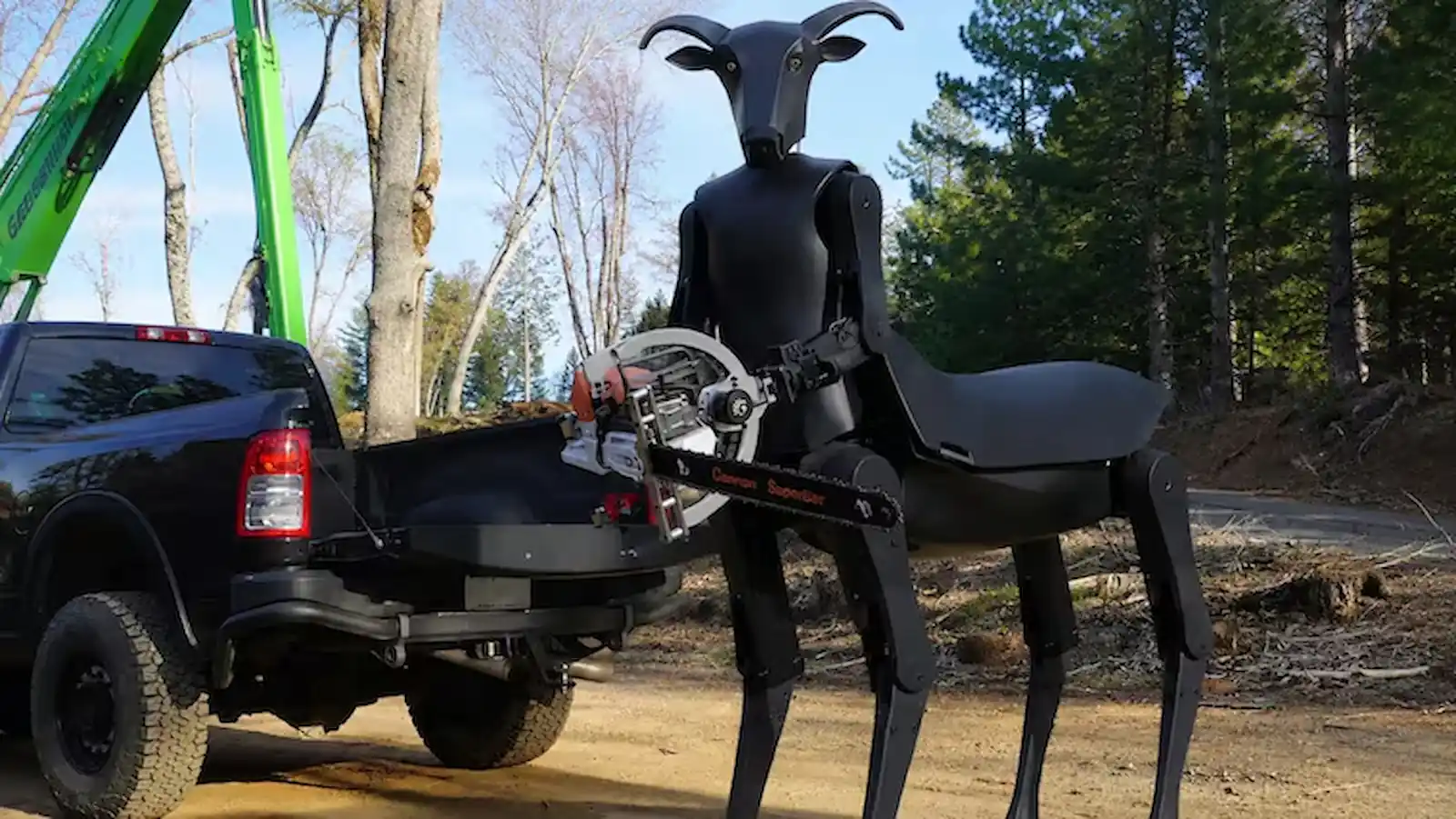 El robot Threehalves manipulando una herramienta junto a la caja de una camioneta pickup en un sitio forestal