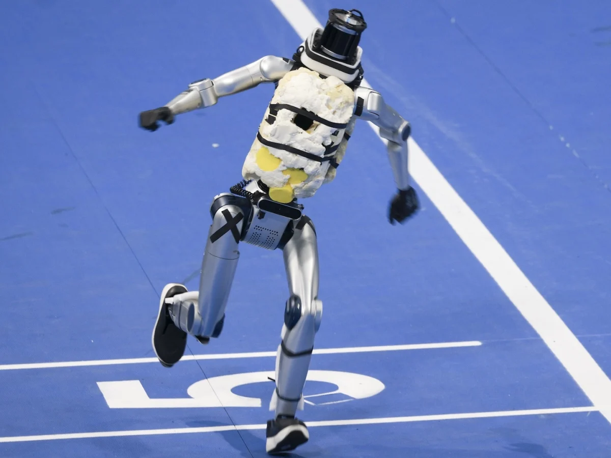 Robot humanoide en plena carrera sobre la pista azul de los World Humanoid Robot Games de Beijing