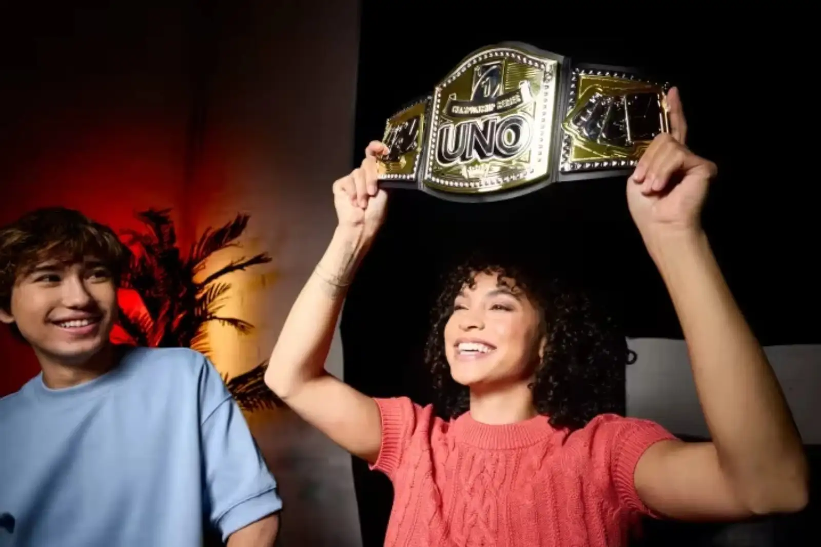 Dos jugadores de UNO celebran con el cinturón de la Championship Series