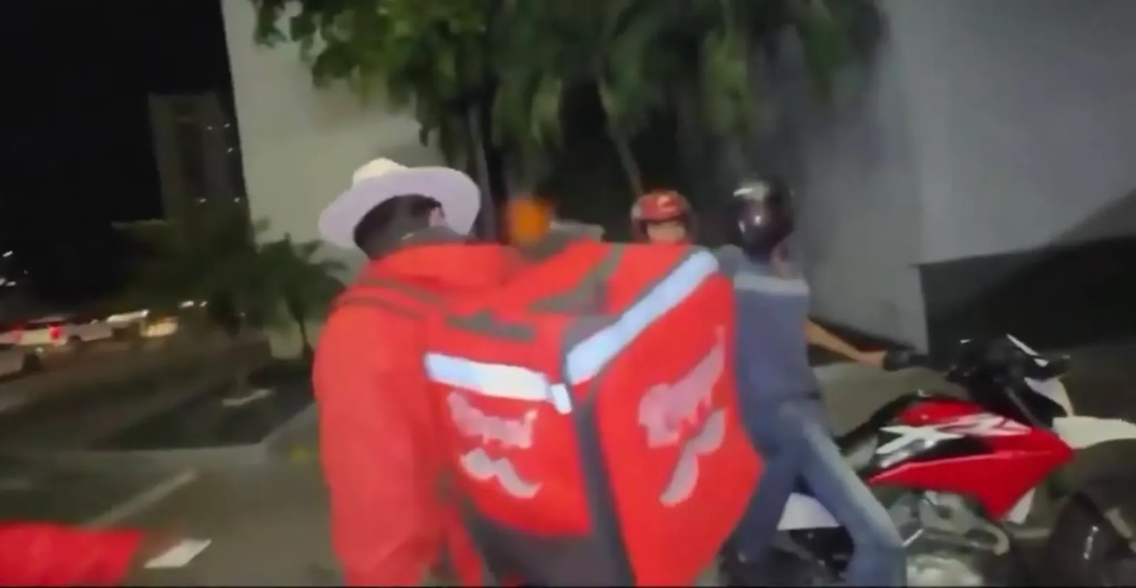 Frame de la transmisión en vivo de César Gastélum con una moto con dos personas detenida al fondo