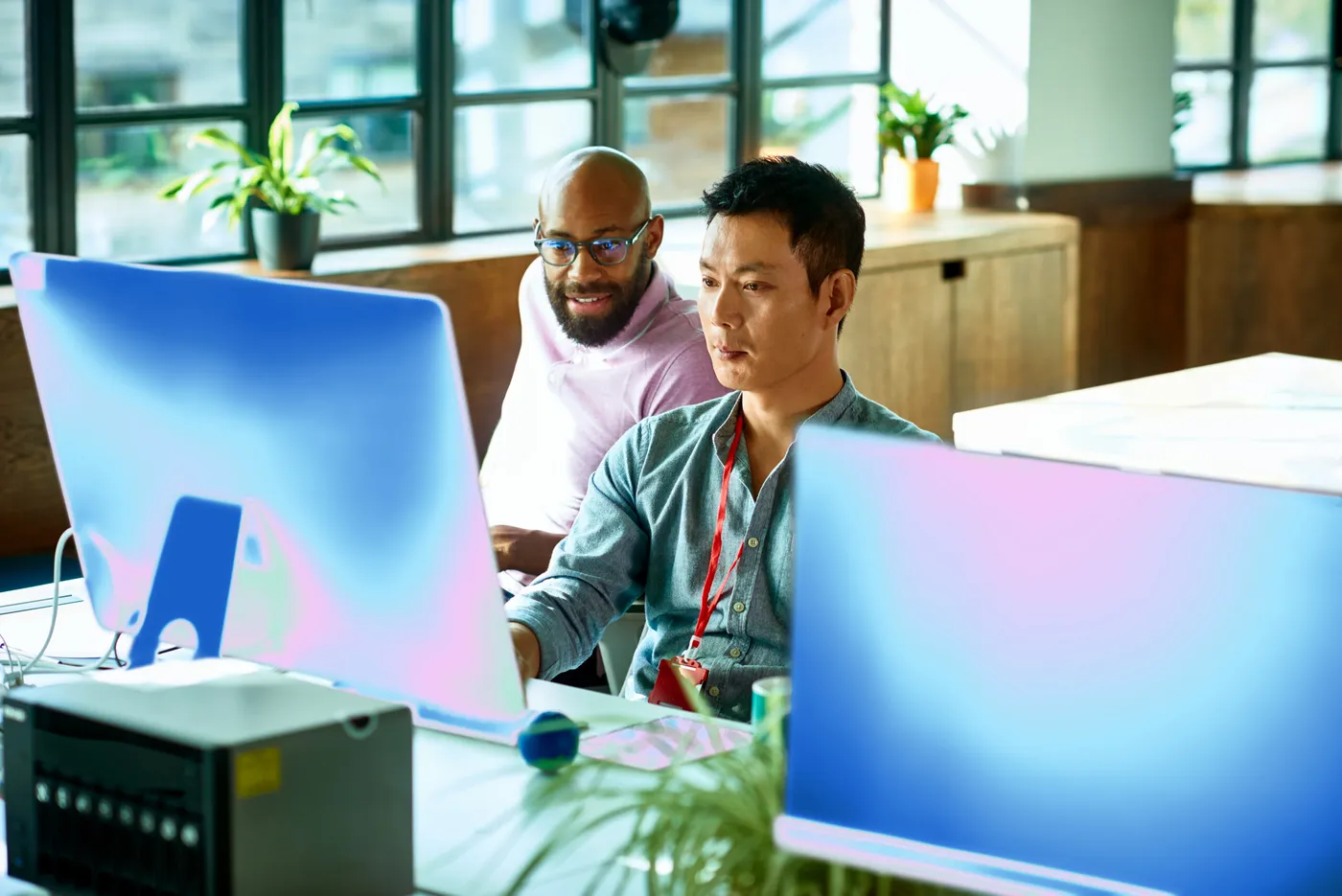 Dos personas trabajando frente a monitores en una oficina, en una imagen del blog de Microsoft Security