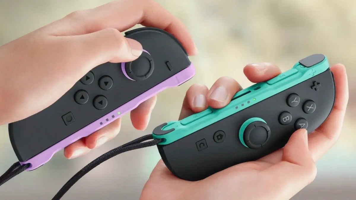 Joy-Con 2 de Nintendo Switch 2 en manos de un jugador, en colores violeta y verde agua