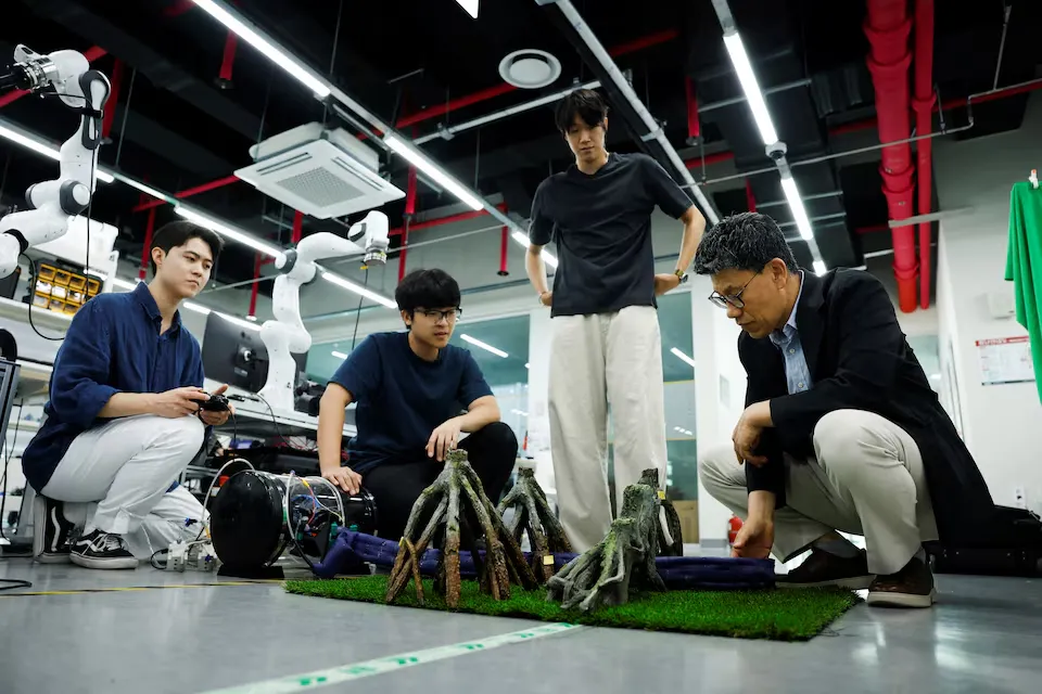 El equipo de investigadores de KAIST observa la estructura de enredaderas robóticas apoyada sobre césped artificial
