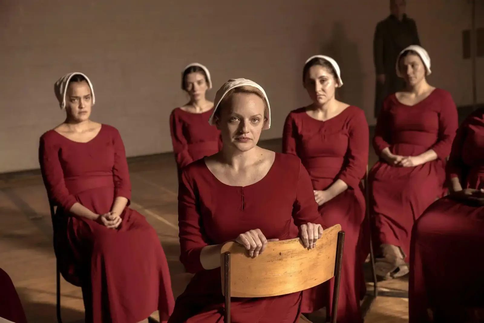 Las Criadas de Gilead sentadas en fila en The Handmaid's Tale, la serie distópica basada en la novela de Margaret Atwood