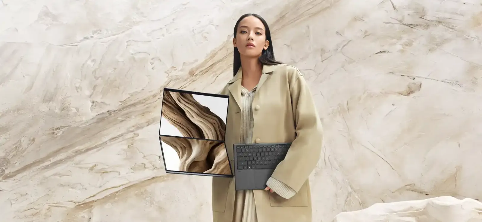 Mujer sosteniendo la ASUS Zenbook DUO con sus dos pantallas y el teclado desmontable