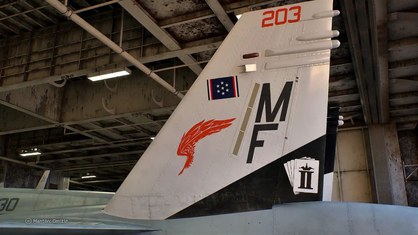 Cola de un caza con el emblema del escuadrón dentro del hangar
