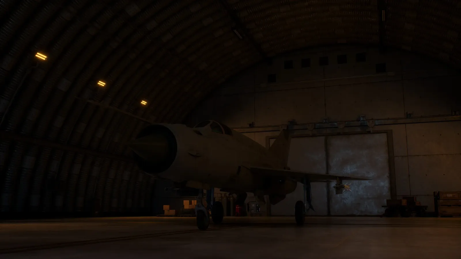 Un caza guardado en un hangar abovedado en penumbra, con el portón abierto al exterior