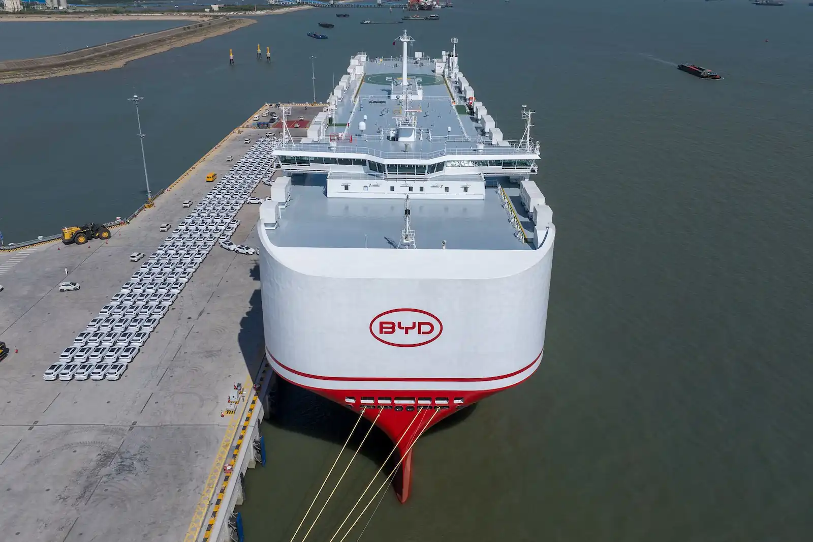 Vista aérea de un carguero de BYD amarrado junto a un muelle con autos