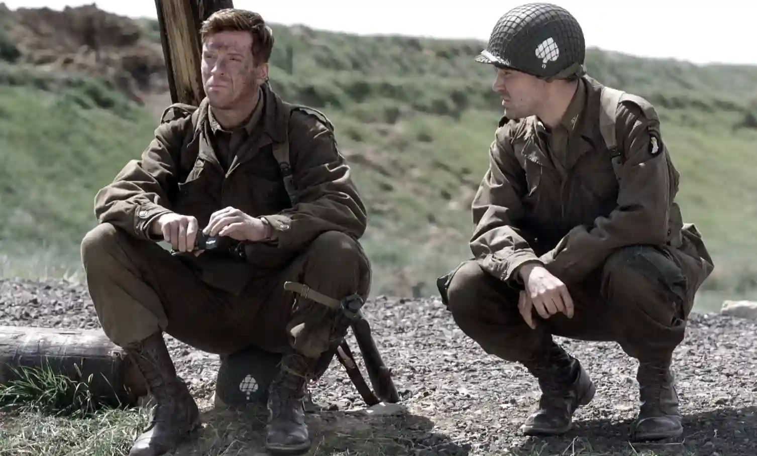 Dos paracaidistas de la Easy Company agachados en un camino en Band of Brothers