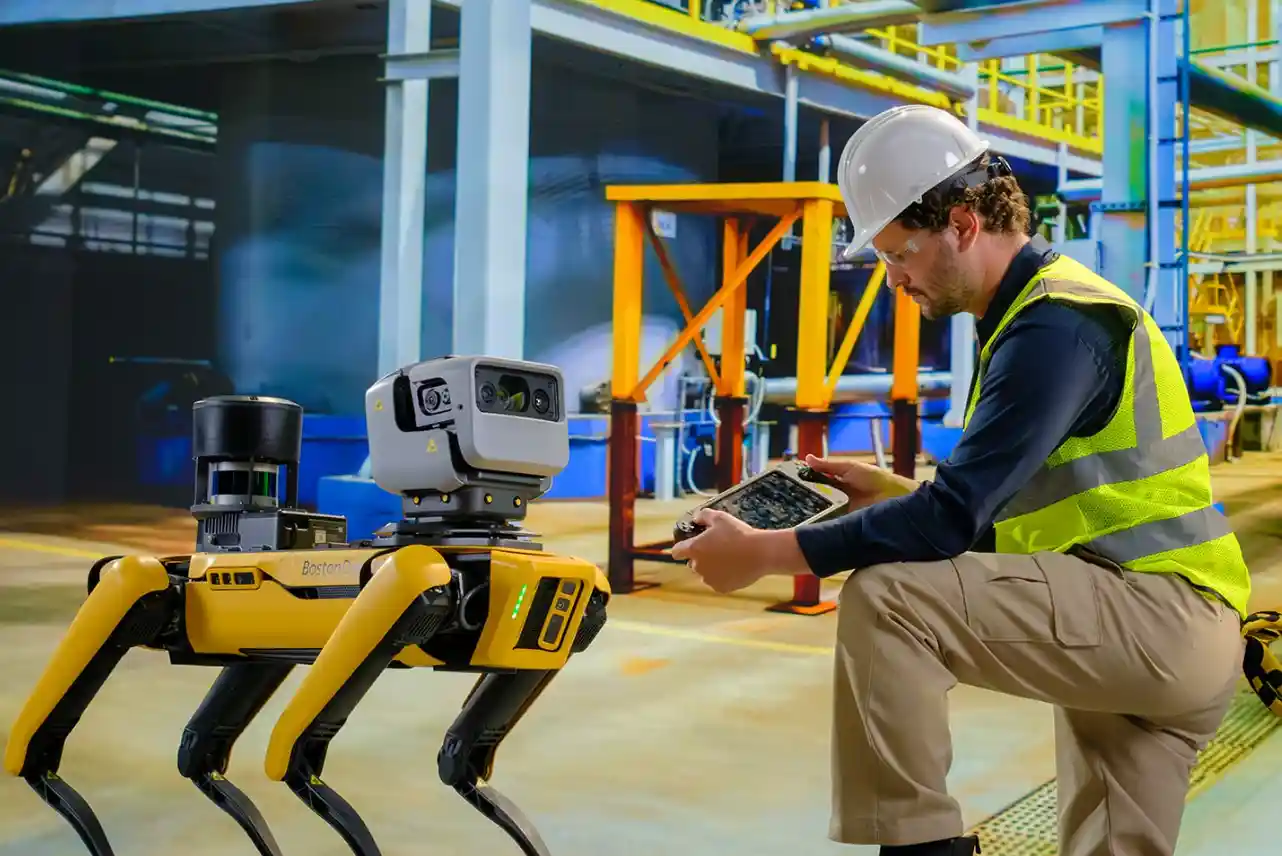 Spot, el robot cuadrúpedo de Boston Dynamics, junto a un técnico en una planta industrial