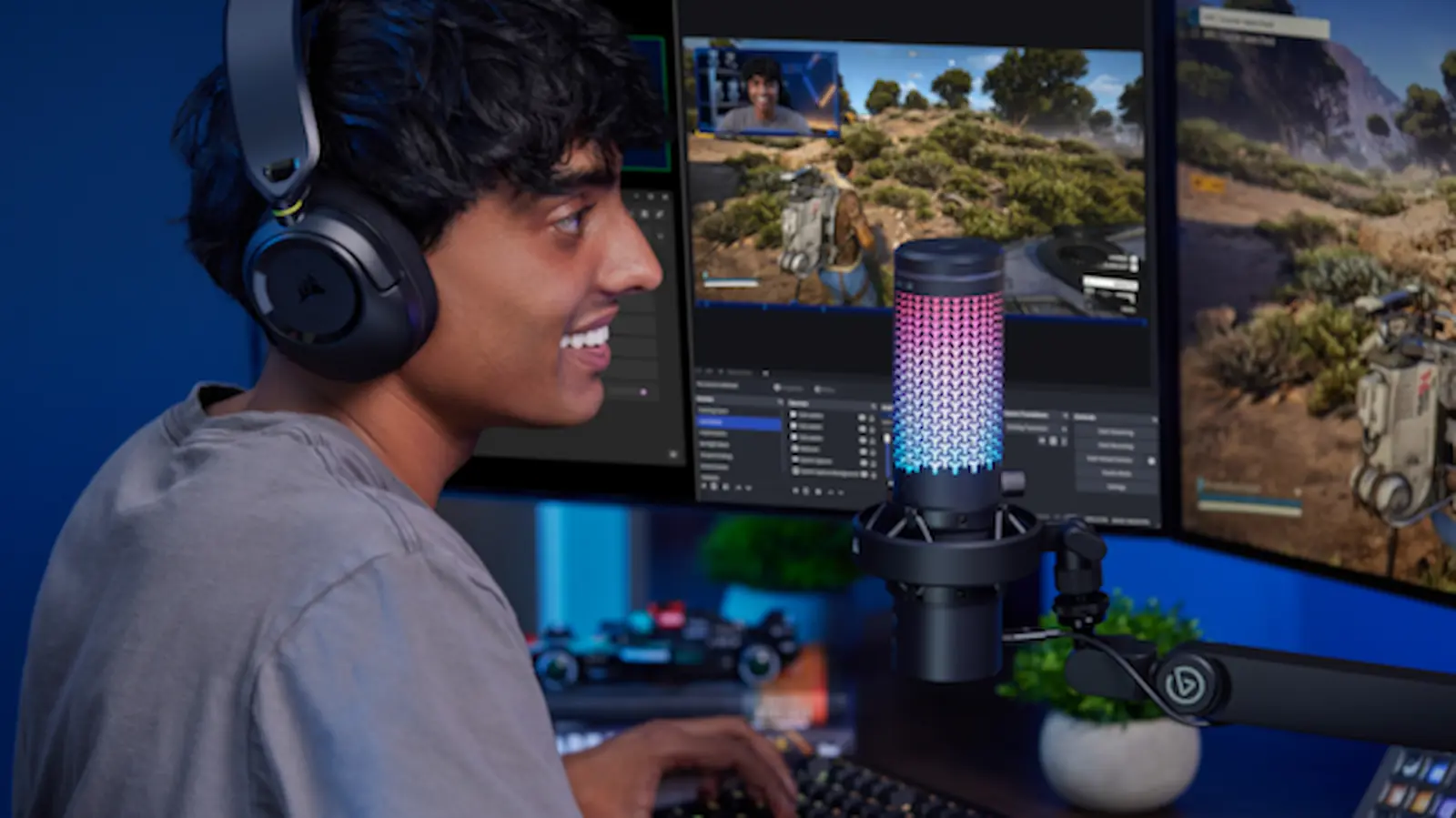 Un streamer frente a su setup con el micrófono Corsair Voxara encendido con luces RGB