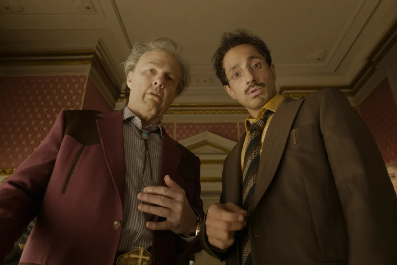 Tom Cruise y Riz Ahmed, de traje y mirando hacia arriba en una escena de Digger, la película de Alejandro G. Iñárritu