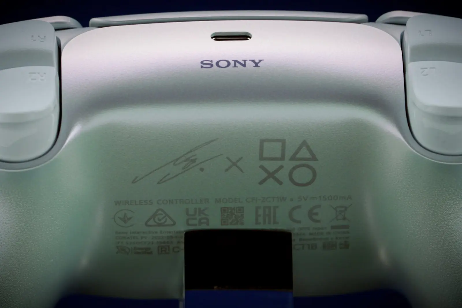 Parte trasera del DualSense Lisa Limited Edition con el logo de Sony y la firma de Lisa
