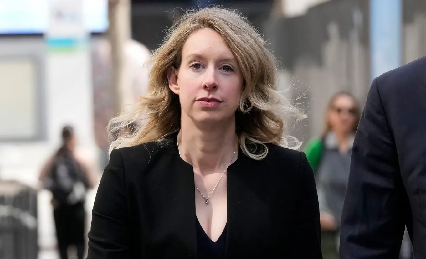 Elizabeth Holmes camina rodeada de gente durante el proceso judicial por el fraude de Theranos