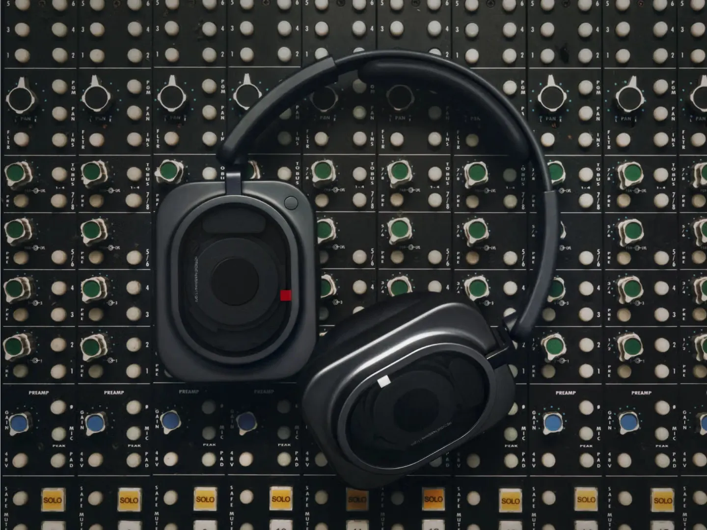 Nothing Headphone (1) Pro negros apoyados sobre una consola de mezcla de estudio
