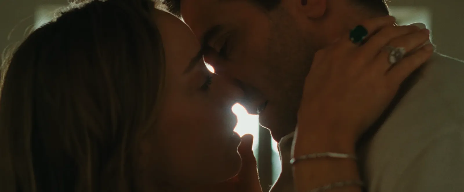 Primer plano de Jake Gyllenhaal y Phoebe Dynevor en un beso a contraluz en Nunca olvides que te quiero