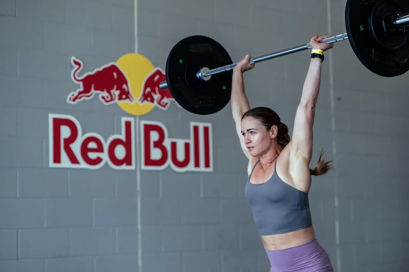 Atleta levantando una barra con discos frente a una pared con el logo de Red Bull, imagen de Red Bull Zero Excusas