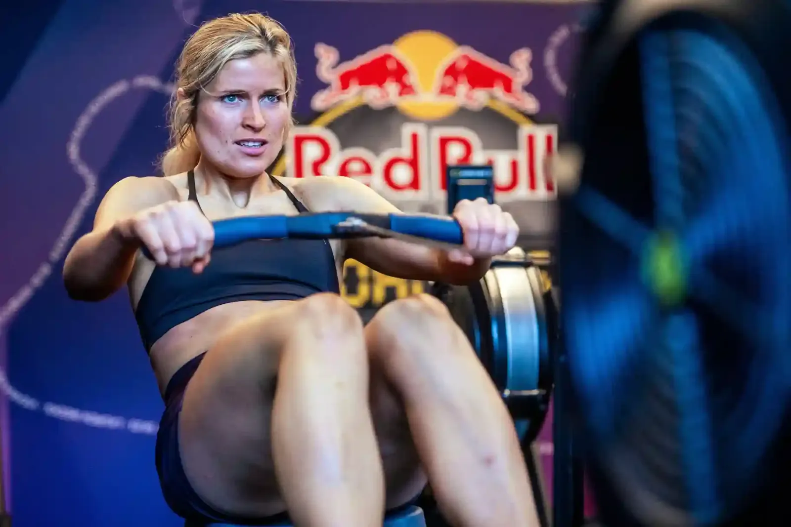 Atleta entrenando en una máquina de remo frente a un logo de Red Bull, imagen de Red Bull Zero Excusas