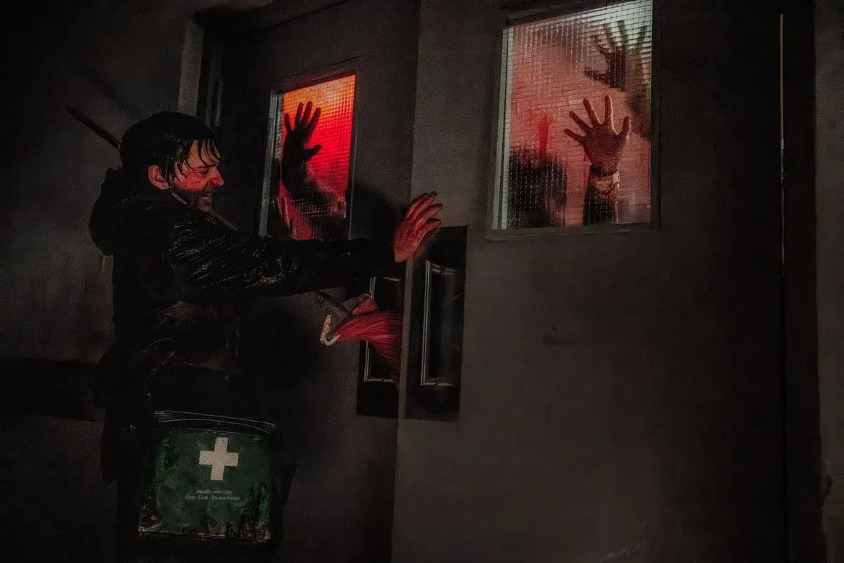 Austin Abrams frente a una ventana con manos ensangrentadas en Resident Evil: Noche Cero