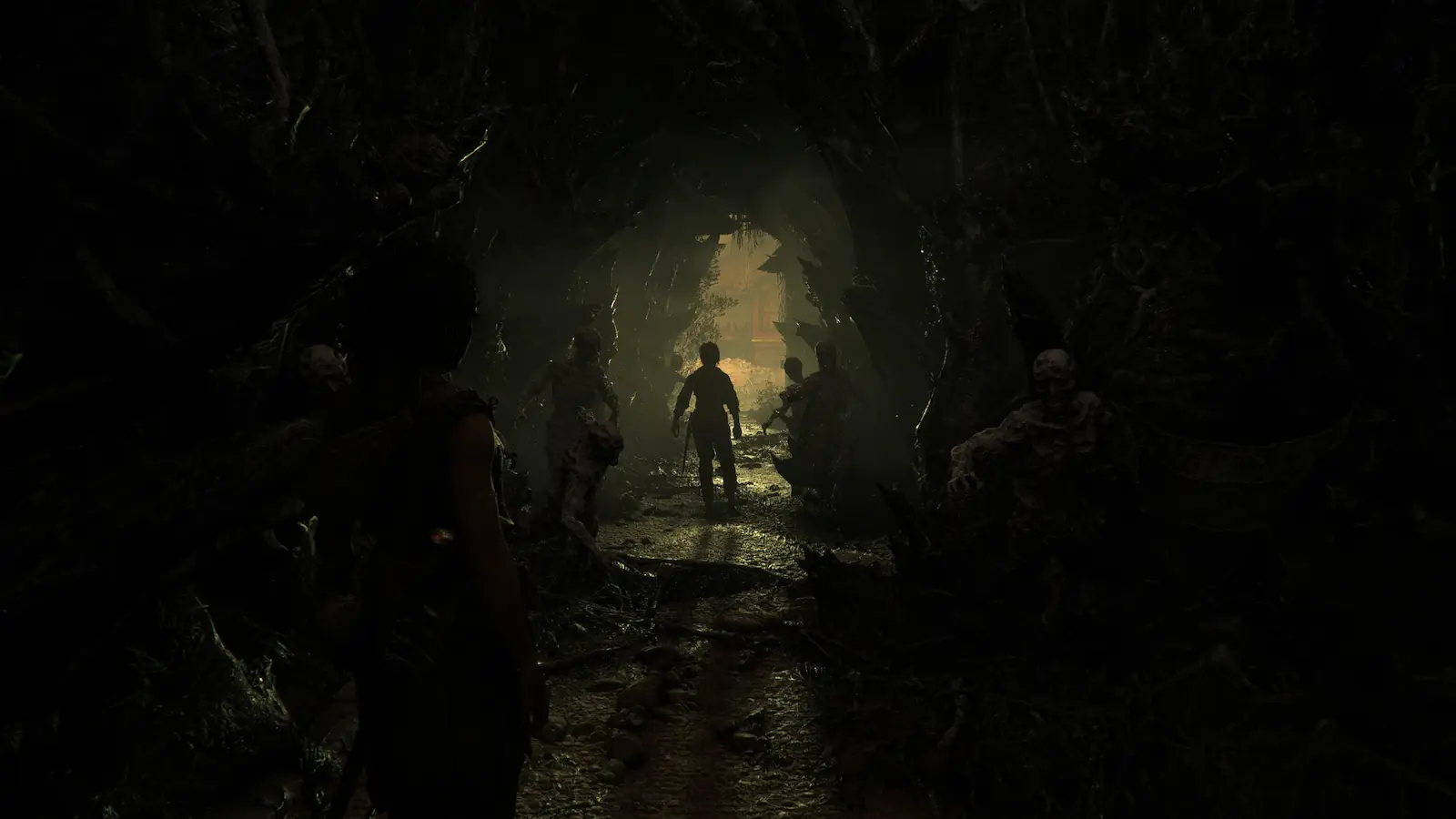 Túnel de raíces y cadáveres con una figura que camina hacia una salida iluminada