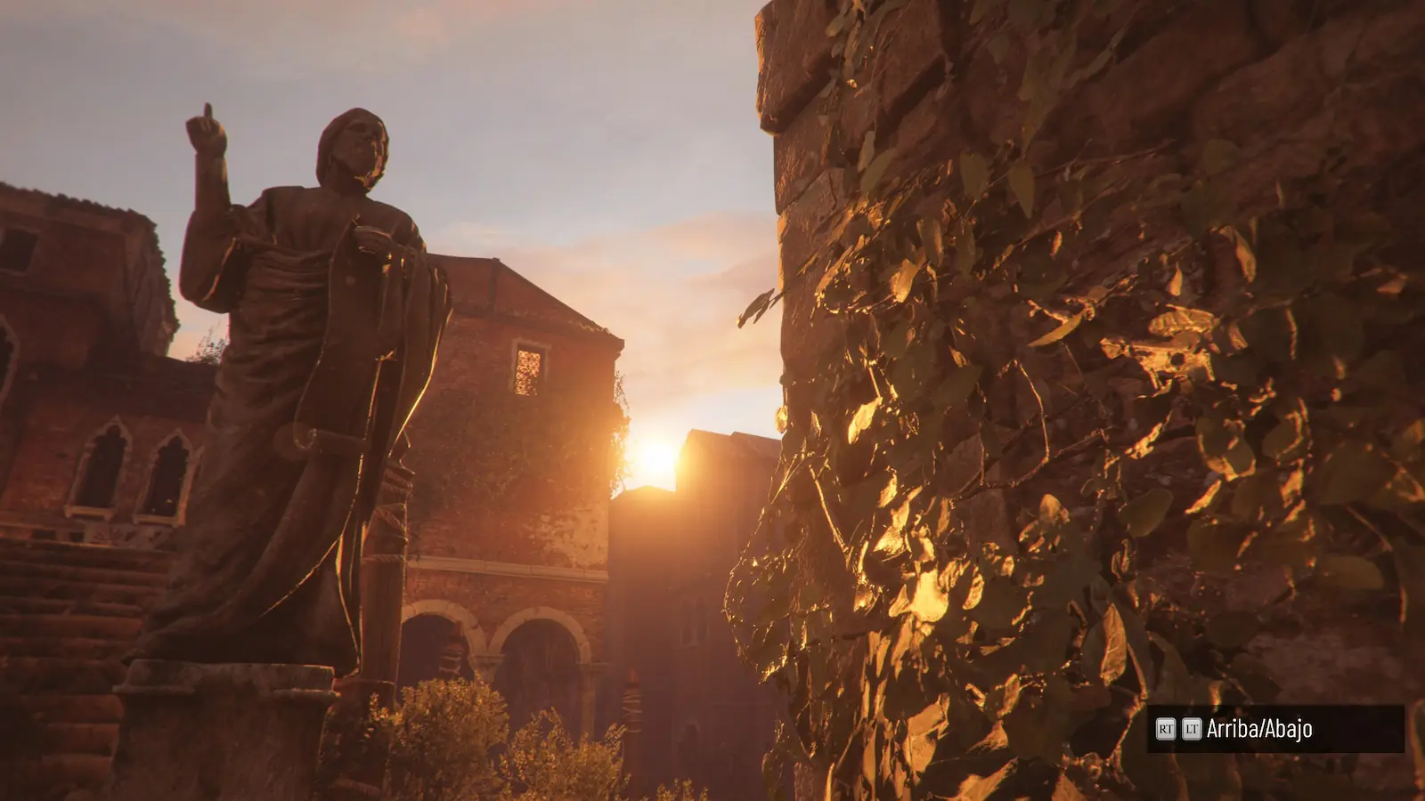 Estatua de piedra entre edificios de ladrillo y una pared cubierta de hiedra al atardecer